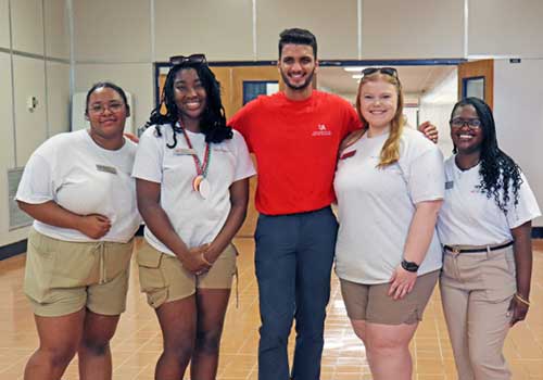 Female student with backpack on standing outside on campus.