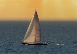 sailboat in the calm ocean at sunset